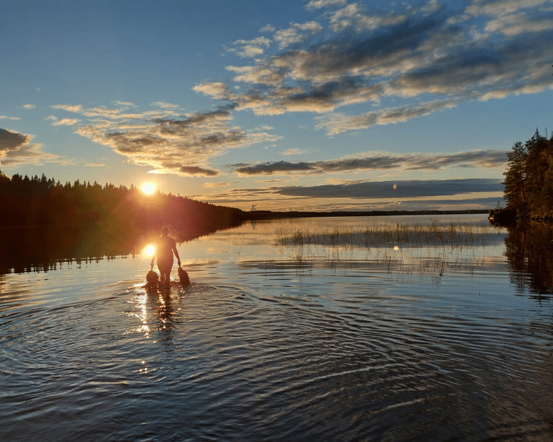 sauna-sunset silhouette of a woman walking towards sunset in a lage
